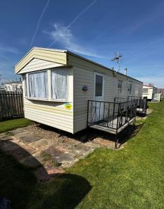 a tiny house in a yard with a porch at Golden Sands Park Ingoldmells in Ingoldmells