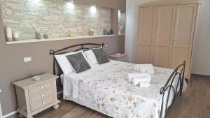 a bedroom with a bed and a stone wall at Citrus Giallo in Siracusa