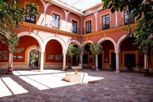 a building with a courtyard with a fountain in it at Casa Palacio de los Palma in Écija