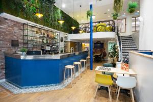 a restaurant with a blue bar with stools at Hotel The Playce by Happyculture in Paris +68 photos