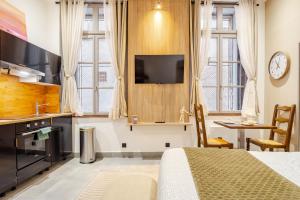 a bedroom with a bed and a kitchen with a table at Studio Luxe & Confort - Elegance Coeur de Béziers in Béziers