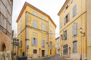 an alley with yellow buildings on a city street at Studio Luxe & Confort - Elegance Coeur de Béziers in Béziers