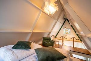a attic room with a bed and a table at Boshuisje Rekem - Ignis in Lanaken