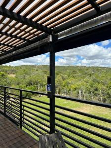 a bench on a deck with a view of a field at casa en villa serrana in Villa Serrana