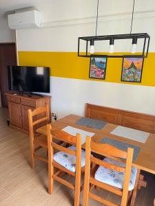 a dining room with a table and chairs and a tv at Casa Rio - Relax on Lake Como with Wi-Fi and Air Conditioning in Colico