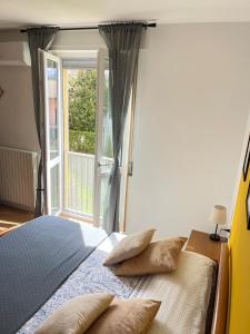 a bedroom with a bed with pillows and a window at Casa Rio - Relax on Lake Como with Wi-Fi and Air Conditioning in Colico +42 photos