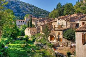 un grupo de edificios en un pueblo en una colina en La maison de Jules, en Saint-Guilhem-le-Désert