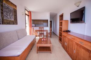 a living room with a couch and a flat screen tv at Servatur Caribe in Playa de las Americas +56 photos