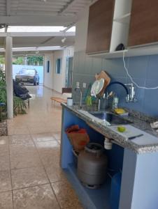 a kitchen with a sink and a living room at Família munhoz in Cananéia