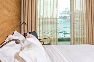 a bedroom with a bed and a window with a cruise ship at Octant Ponta Delgada in Ponta Delgada