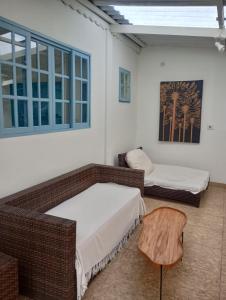 a room with two beds and a chair in it at Família munhoz in Cananéia