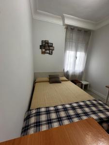 a bedroom with a bed in a room with a window at 3 habitaciones reformado y centrico in Santander
