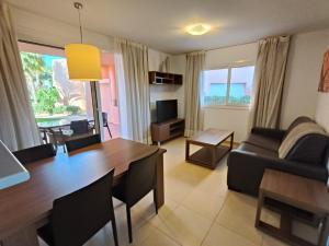 a living room with a dining room table and a couch at Mar Menor Golf Resort, Fitnes, Tennis, wellness, Security! in Torre-Pacheco