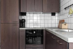 a kitchen with wooden cabinets and a stove top oven at Luxurious apartment for the modern executive in Luleå +9 photos