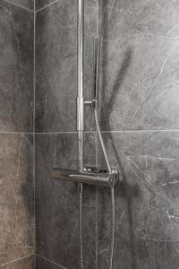 a shower with a shower head on a wall at Luxurious apartment for the modern executive in Luleå
