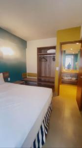 a bedroom with a white bed in a room at Apto em Olímpia- Enjoy Solar das Águas Park Resort in Olímpia