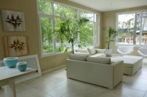 Una sala de estar con muebles blancos y grandes ventanales. en Sea View by CELTIS, en Cariló 12 fotos más
