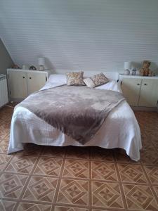 a bedroom with a large bed with white sheets and pillows at La chambre aux papillons in Huismes