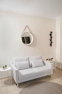 a white living room with a white couch and a mirror at Rokani Studio I at Kalavrita Center in Kalavrita +17 photos