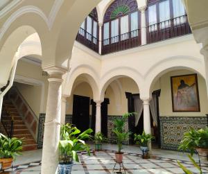 a building with a staircase and potted plants at Casa Palacio Domus Astigi in Écija