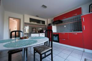 a kitchen with red cabinets and a table and chairs at Appartement Le Balcon de L'Oust in Malestroit