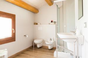 a white bathroom with a toilet and a sink at Agriturismo Monte Scala in Taglio di Po