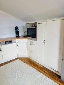 a kitchen with white cabinets and a microwave at Laichingen Center with style & tranquility in Laichingen +7 photos