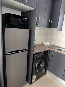 una cocina con nevera y lavadora en Cozy Retreat with a Pool!, en Cape Town