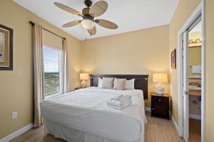 una camera con letto bianco e ventilatore a soffitto di Splash Beach Resort #1503-E by Book That Condo a Panama City Beach Altre 86 foto