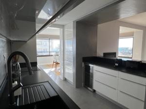a kitchen with white cabinets and a black counter top at FLH Cascais Atrium Luxury Apartment with Sea View and Pool in Cascais