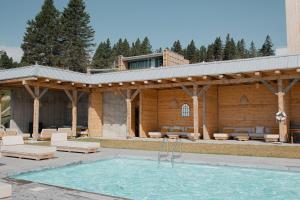 un pabellón con piscina frente a un edificio en Villa La Charbonnière, en La Malbaie