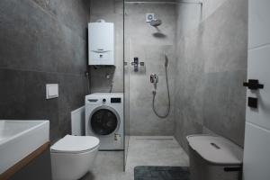 ein Badezimmer mit Toilette und Waschmaschine in der Unterkunft FOUR Seasons by DISTRICT in Osijek