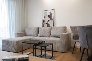 ein Wohnzimmer mit einer Couch und zwei Sesseln in der Unterkunft FOUR Seasons by DISTRICT in Osijek