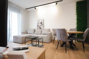 ein Wohnzimmer mit Sofa und Tisch in der Unterkunft FOUR Seasons by DISTRICT in Osijek