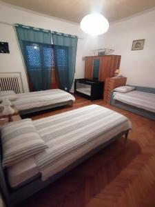 a room with three beds and a table at Villetta la Fortezza Oasi Verde e Relax Toscano in Radicofani