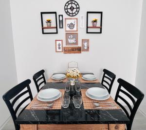 a dining room table with chairs and a clock on the wall at Barış Apart in Dalaman