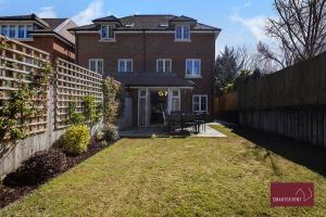 a brick house with a fence in front of it at Maidenhead - 4 bedroom house - garden and parking in Maidenhead