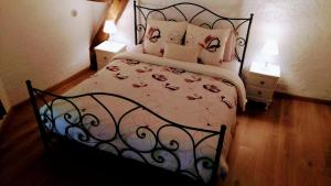 a bedroom with a bed with a black frame and pillows at La tour du logis in Chéneché