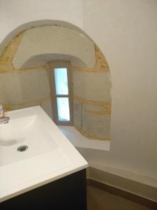 a bathroom with a sink and a window at La tour du logis in Chéneché +14 photos