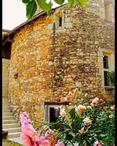 a brick building with stairs and flowers in front of it at La tour du logis in Chéneché
