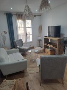 a living room with a couch and chairs and a table at Maison dépaysante au calme Soyaux Angoulême in Soyaux