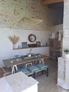 a dining room with a table and chairs and a clock at Maison dépaysante au calme Soyaux Angoulême in Soyaux