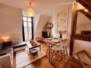 a living room with a table and a couch at Appartement Albuconis 4, deux chambres 70 M2 in Aubusson