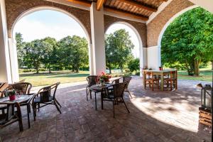 an outdoor patio with tables and chairs and arches at Agriturismo Monte Scala in Taglio di Po