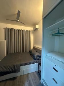 ein kleines Schlafzimmer mit einem Bett und einer Kommode in der Unterkunft Coral Stay Rooms in Hulhumale