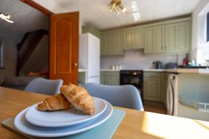 a plate with a croissant on a table in a kitchen at Eastwood in Colchester +12 photos