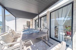 a dining room with a table and chairs on a balcony at Seaside Holiday Home Ema in Vela Luka