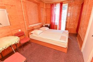 a small bedroom with a bed and a window at Nakvynė prie ežero Akmenėlis in Dyviliškiai