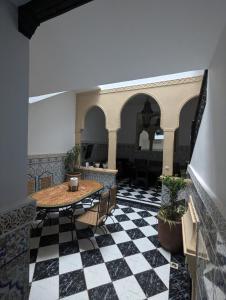 Habitación con mesa y suelo a cuadros en blanco y negro. en Almohafidon room, en Marrakech