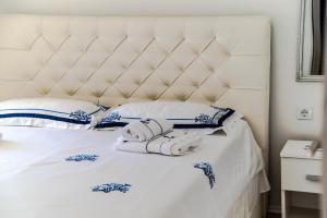 a white bed with towels and pillows on it at Seaside Holiday Home Ema in Vela Luka